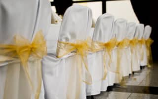 Gold Bow on White Chairs in a Row